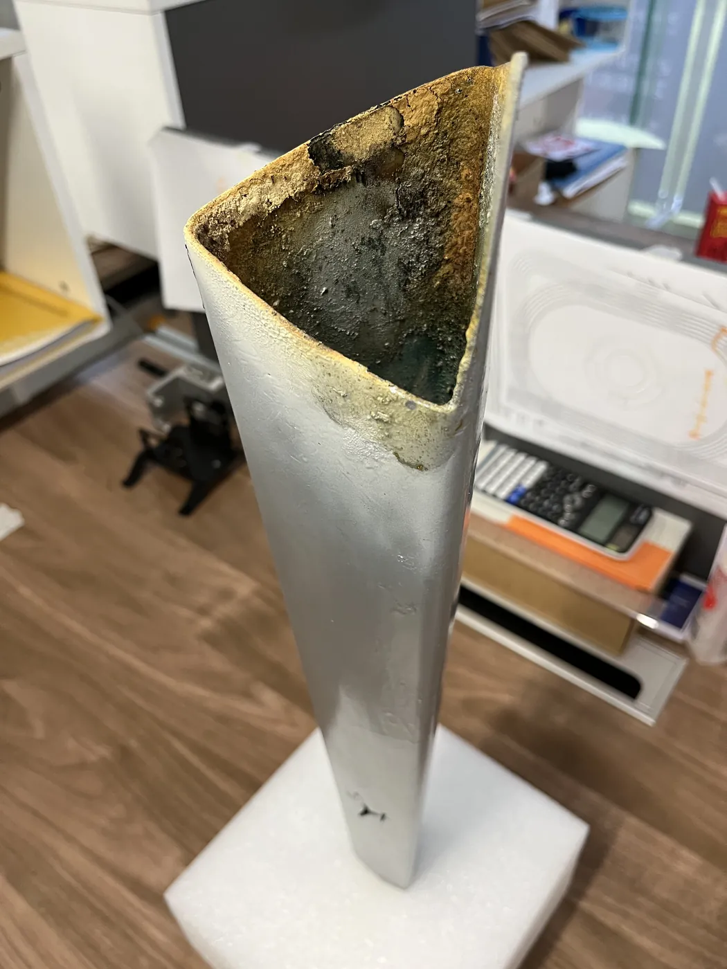 A weathered torch prototype on a white stand in the studio